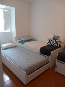 two twin beds in a room with a window at Snow Guest House in Santarém