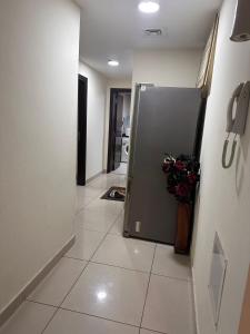 a hallway with a refrigerator with a vase of flowers at One BHK in Ajman 