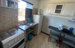 a small kitchen with a sink and a refrigerator at Apartamento a 1 km da Orla in Aracaju