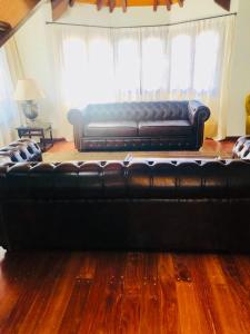 a black leather couch sitting in a living room at Juancito Ángel in Río Cuarto