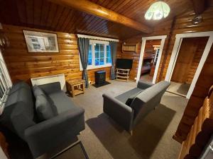 a living room with two couches and a television at Snowdonia Escape in Trawsfynydd