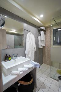 bagno con lavandino bianco e doccia di Theo and MS Luxurious Apartments a Città di Kos