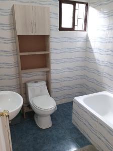 a bathroom with a toilet and a sink and a tub at Cabañas doña carmen in Punta de Choros