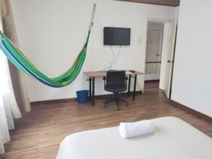 a bedroom with a bed and a desk and a television at Casa en Bogotá ubicada en zona central in Bogotá
