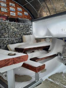 una habitación con asientos cubiertos de nieve y una mesa en Pensiunea K9, en Răchiţele