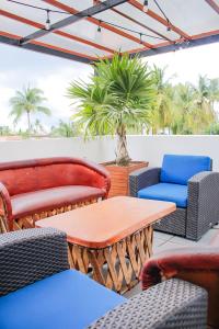 um pátio com cadeiras, mesas e palmeiras em Refugio del Mar Luxury Hotel Boutique em Bucerías