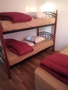a room with two bunk beds with red pillows at cabañas de la casona in Punta de Choros