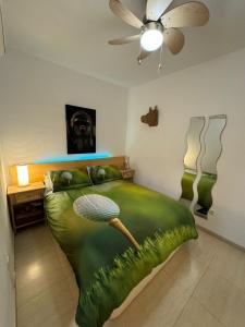 Schlafzimmer mit einem großen grünen Bett und einem Ventilator in der Unterkunft Apartamento en Valle del este Golf, OLV in Vera
