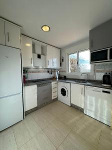 eine Küche mit weißen Schränken und einem Geschirrspüler in der Unterkunft Apartamento en Valle del este Golf, OLV in Vera