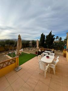eine Terrasse mit einem Tisch, Stühlen und Sonnenschirmen in der Unterkunft Apartamento en Valle del este Golf, OLV in Vera