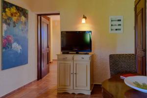 uma sala de estar com uma televisão de ecrã plano num armário em N A P L house em Keramiaí
