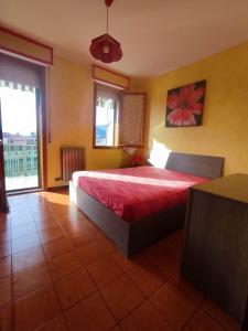 a bedroom with a bed with a red bedspread at Casa Agave in Ventimiglia