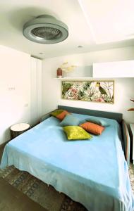 sypialnia z dużym niebieskim łóżkiem z poduszkami w obiekcie AMBER APARTMENTS - FRESH STUDIO w mieście Morro del Jable +26 zdjęć
