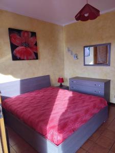 a bedroom with a large bed with a red blanket at Casa Agave in Ventimiglia