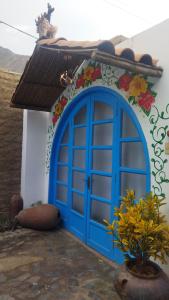 una porta blu sul lato di una casa di Ayahuaska Hotel a Lunahuaná