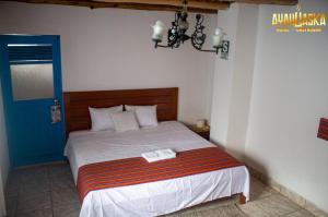 una camera con un letto e una porta blu di Ayahuaska Hotel a Lunahuaná