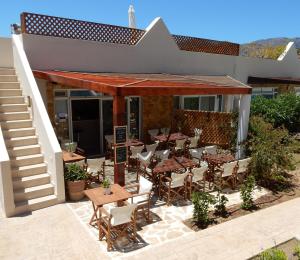 an outdoor patio with tables and chairs and stairs at Townhouse 23, Lagada Resort in Makry Gialos