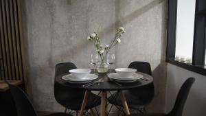 una mesa negra con gafas y un jarrón de flores en Chemików Point by sleepwell, en Nowy Dwór Mazowiecki