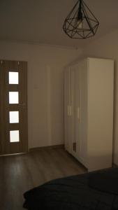a room with a bed and a cabinet and a light at Chemików Point by sleepwell in Nowy Dwór Mazowiecki