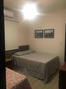 a bedroom with two beds and a light on the wall at Bela casa de praia, arborizada, um paraíso! in Salvador +12 photos