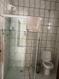 a small bathroom with a toilet and a shower at Bela casa de praia, arborizada, um paraíso! in Salvador