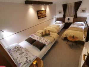 Cette chambre comprend 3 lits et une table. dans l'établissement Planinska idila - uz stazu, à Jahorina