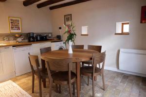 a kitchen with a wooden table with chairs and a vase with flowers at Sessius1622 in Cessy