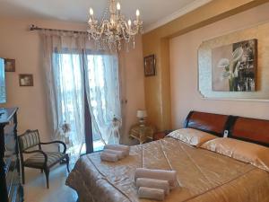 a bedroom with a large bed and a chandelier at Limoneto Etna View in Giarre