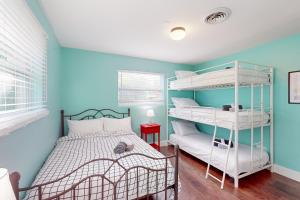 een slaapkamer met een stapelbed en een blauwe muur bij Prize Catch in Palm City
