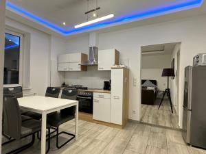 cocina con mesa, sillas y nevera en FeWo Apartments House, en Essen