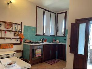 een keuken met een spoelbak en een fornuis bovenste oven bij Al mare nella natura selvaggia in Buggerru +12 foto's