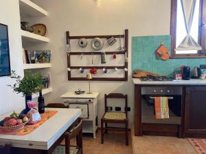 een kleine keuken met een tafel en een fornuis bij Al mare nella natura selvaggia in Buggerru