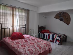 a bedroom with two beds and a window at Pousada Arvoredo in Contagem