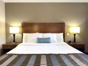 a bedroom with a large bed with two lamps at Super 8 by Wyndham Greensburg in Greensburg