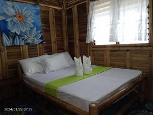 a bedroom with a bed with white shoes on it at NATUA'S BEACH RESORT in Liminangcong