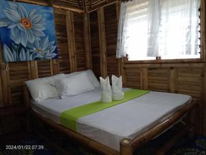 a bedroom with a bed with white shoes on it at NATUA'S BEACH RESORT in Liminangoon