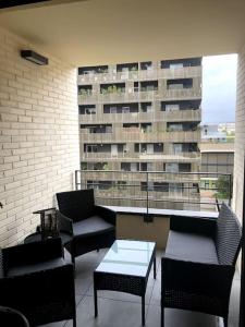 a balcony with chairs and a table and a building at Charmant T2 à port Marianne in Montpellier