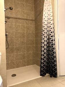 a shower with a black and white shower curtain at Charmant T2 à port Marianne in Montpellier