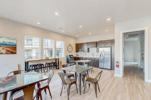 a living room with tables and chairs and a kitchen at Modern Delight-Ocotillo 54 in Santa Clara