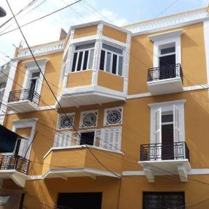 a yellow building with white windows and balconies at City Hostel Dormitory in Tr&acirc;blous