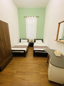 a hospital room with two beds and a desk at City Hostel Dormitory in Trâblous