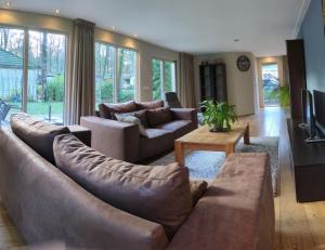 a living room with two couches and a television at 8 pers vakantiehuis met natuur- sauna en bubbelbad in Diessen
