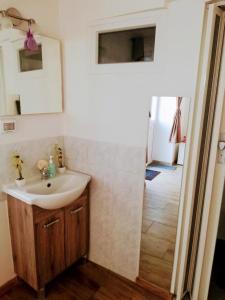 ein Bad mit einem Waschbecken und einem Spiegel in der Unterkunft Apartma SunySun in Koper