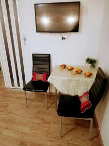 ein Esszimmer mit einem Tisch und 2 Stühlen in der Unterkunft Apartma SunySun in Koper