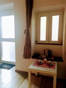 einen kleinen Tisch in einem Zimmer mit zwei Fenstern in der Unterkunft Apartma SunySun in Koper