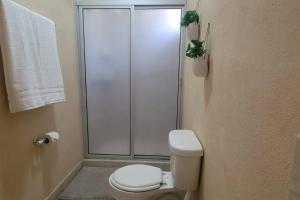 a bathroom with a toilet and a glass shower at Casita Bambú cerca del aeropuerto SJD in San José del Cabo