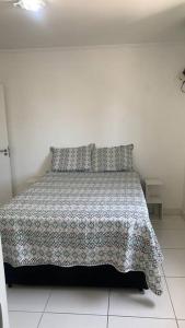 um quarto com uma cama com um cobertor e almofadas em Apartment 200 Mt Da Praia na Praia Grande
