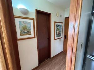 a hallway with a door and two pictures on the wall at Amazing Flat - Setor Oeste in Goiânia