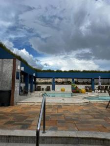 a patio with a pool and a blue building at Amazing Flat - Setor Oeste in Goiânia