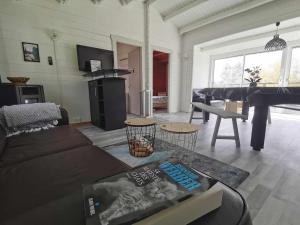 a living room with a couch and a piano at Bienvenue au CHAT LAIT ! in Seilhac